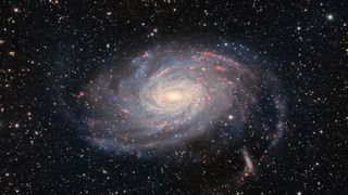 A photo of a spiral galaxy with blue and red streaks