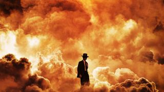 A promotional image for the Oppenheimer movie. Cillian Murphy (playing J. Robert Oppenheimer) stands in front of an explosion. 