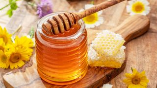 honey in a jar on a wooden plate