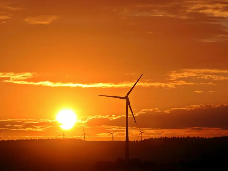 pexels-pixabay-163317-earth4all resource deep dive Photo of a wind turbine against a setting sun and orange sky